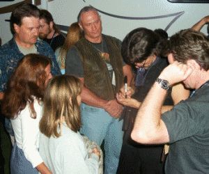 John signing autographs